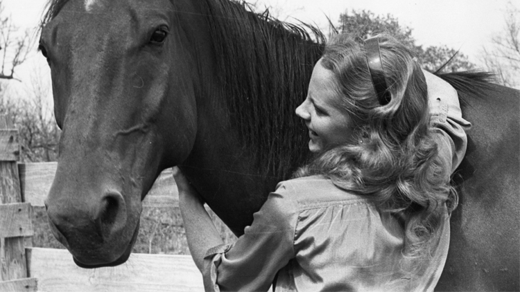 Reba with arms around horse